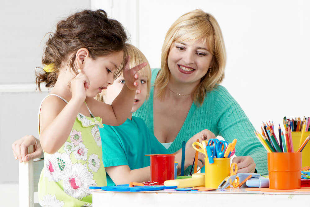 A woman with two toddlers playing. Learn the 11 quick job certifications that pay well here.