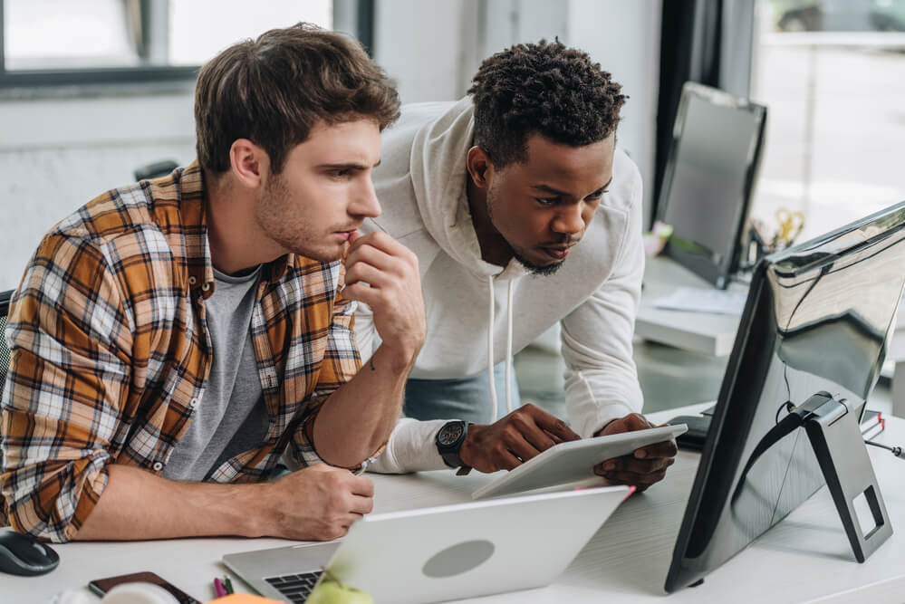 Two men looking at their devices. Find 11 quick job certifications that pay well here.