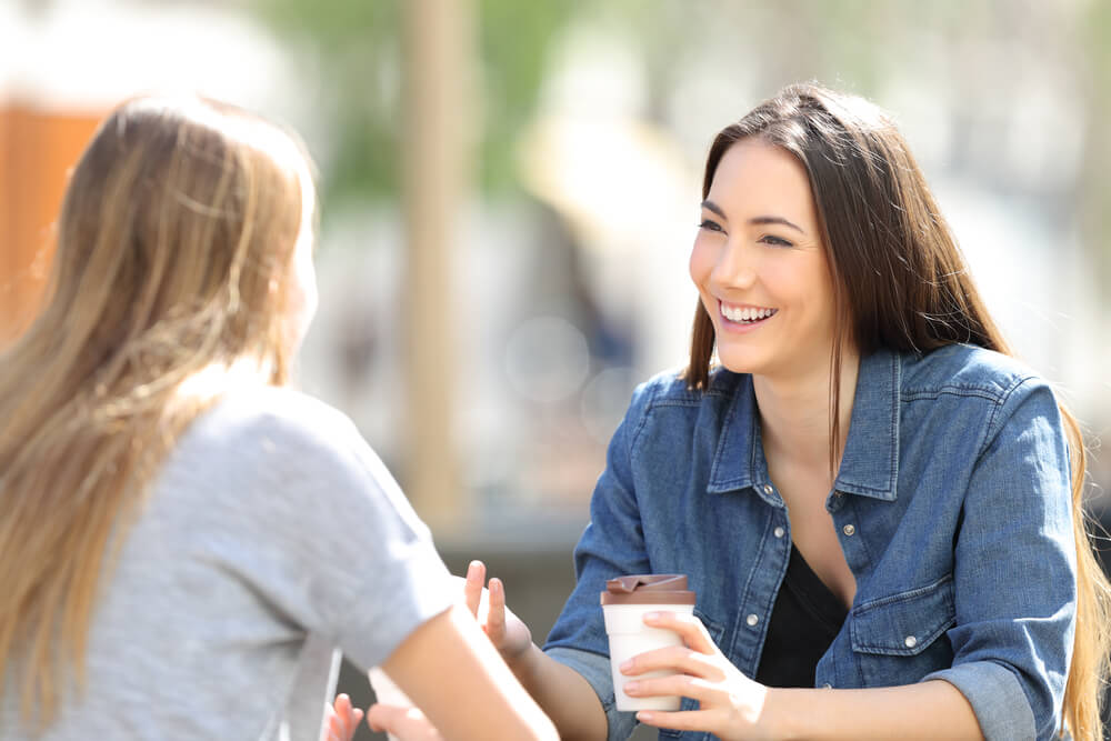 Two women talking. The other one holding a drink. Check on these 31 co-parenting tips to make shared custody a success.