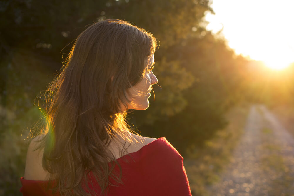 A woman facing the sunset. You can read these 31 co-parenting tips to make shared custody a success here.