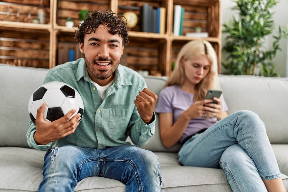 A man holding a soccer ball and a woman texting. Go on and check these 31 co-parenting tips to make shared custody a success.