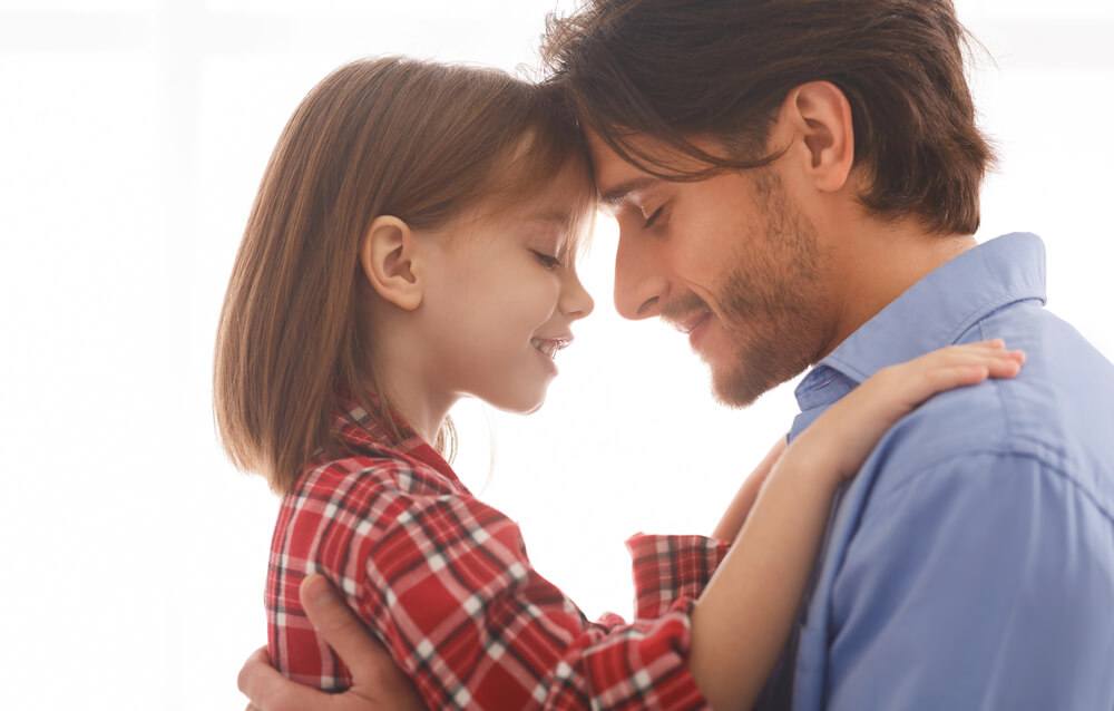 A man forehead to forehead with a child. Read about these 31 co-parenting tips to make shared custody a success.