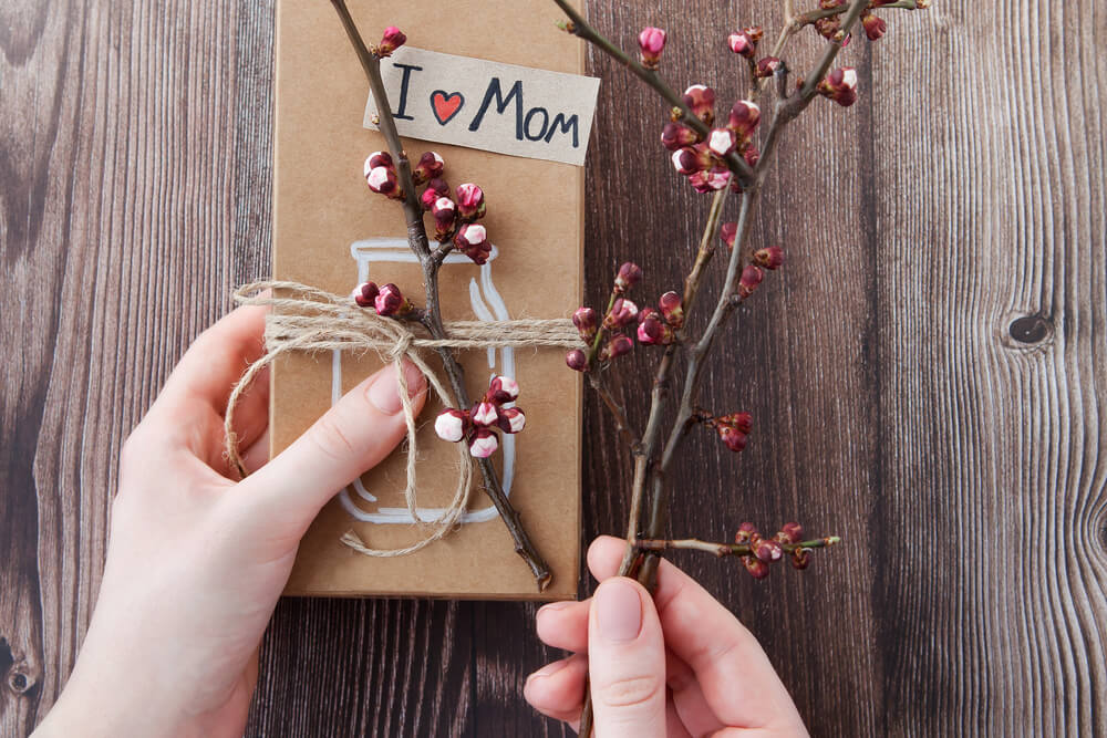Two hands with an I Love Mom gift. Check out 32 best gifts for single moms here.