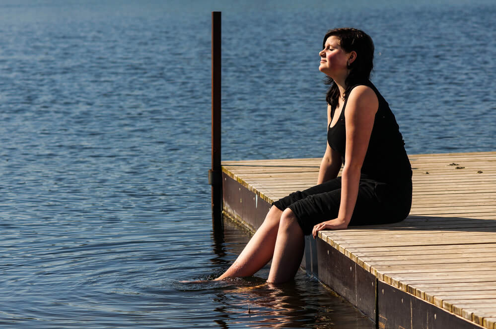A woman sitting alone on the dock. Check out 32 best gifts for single moms here.
