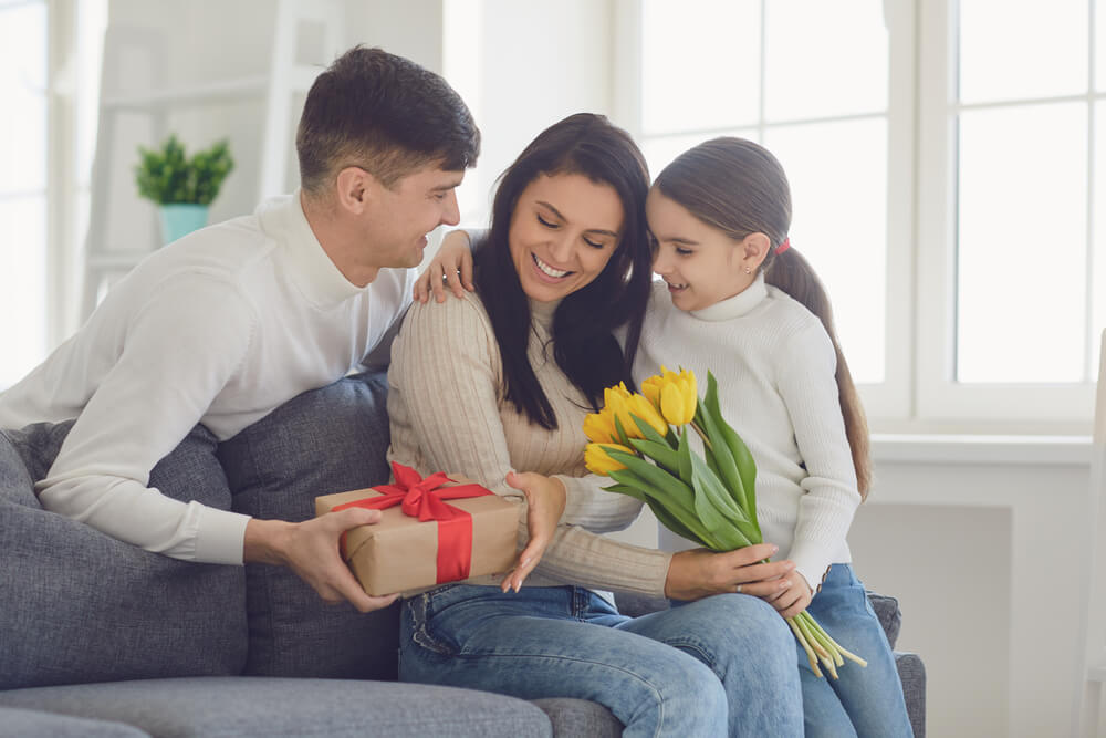 A woman with a child and a man offering flowers and a gift. Find out more about these 5 tips for dating after divorce and what I wish I knew.