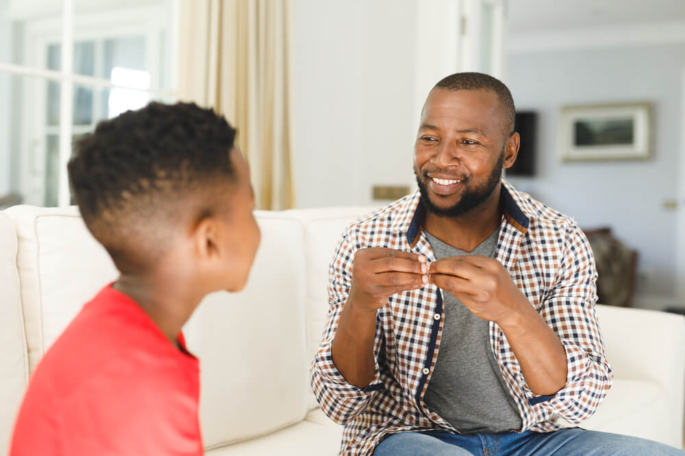 A man talking cheerfully to a child. Check on these 7 benefits of parenting classes and where to find them.