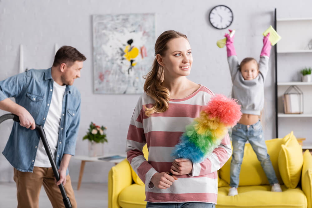 A family cleaning the living room. Check on these 7 benefits of parenting classes and where to find them.