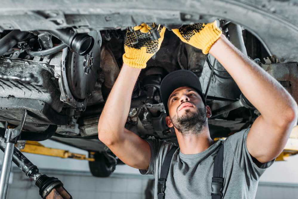 A mechanic works on a car. Auto repair is considered a recession-proof business.