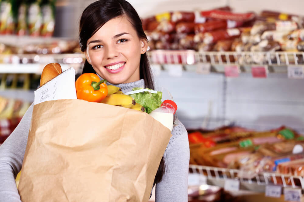 A smiling woman holding a bag of groceries. Read about 9 ways to get free groceries, food, and meals in 2024 9 ways to get free groceries, food, and meals in 2024 here.