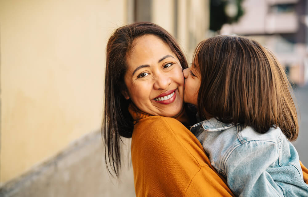 A woman with a child kissing her. Friends after divorce: 7 friends single moms need and where to find them. Learn more about them here.