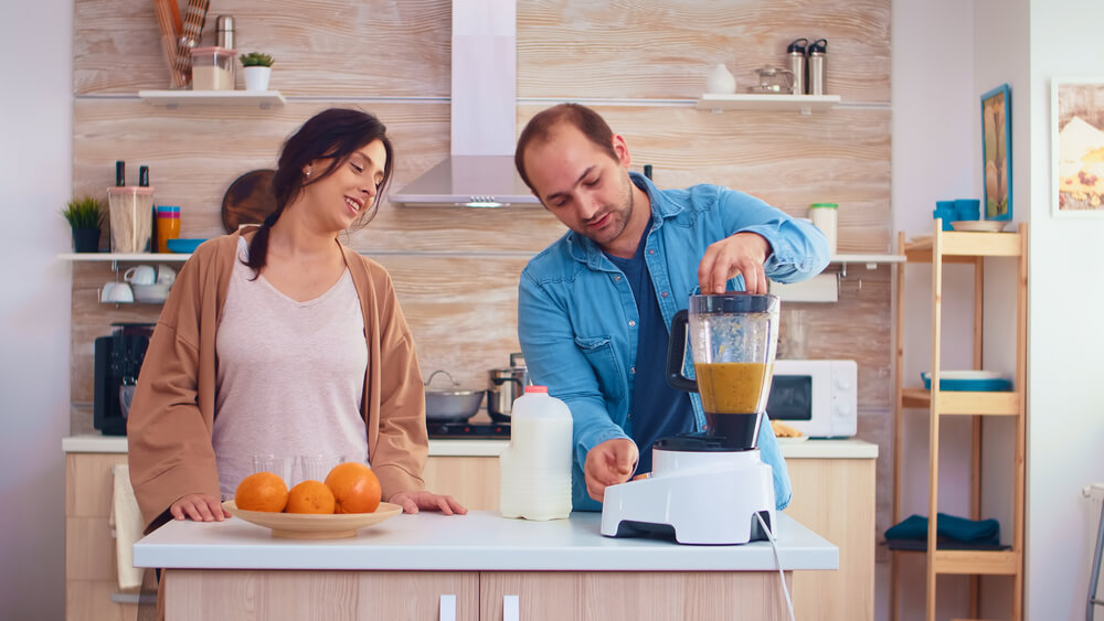 A man and woman making a smoothie. Check here about how to comfort a friend after a breakup or divorce.