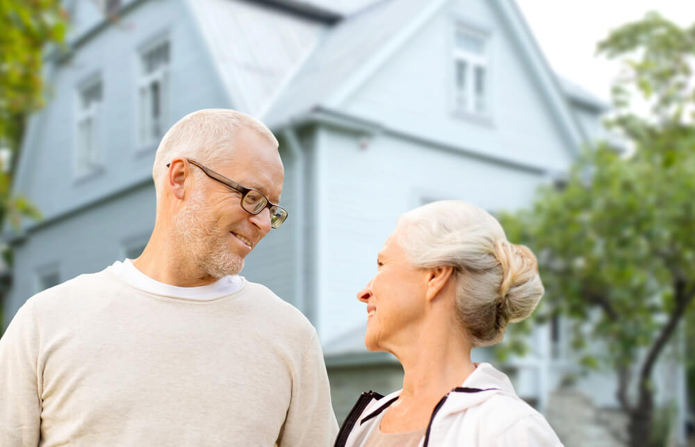 An elderly couple looking at each other with a house for their background. Need money now? 15 ways to get free money instantly Check this out.