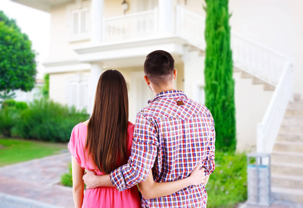 A couple facing a house with hands on each other's waist. Need money now? 15 ways to get free money instantly. Read this.