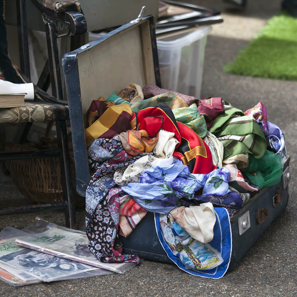 A suitcase of old clothes. What to do with old clothes: 11 tips to recycle, repurpose, and resell.