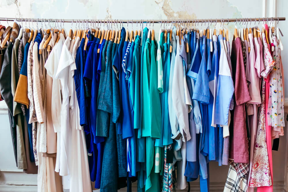 A rack full of used clothes. What to do with old clothes: 11 tips to recycle, repurpose, and resell.