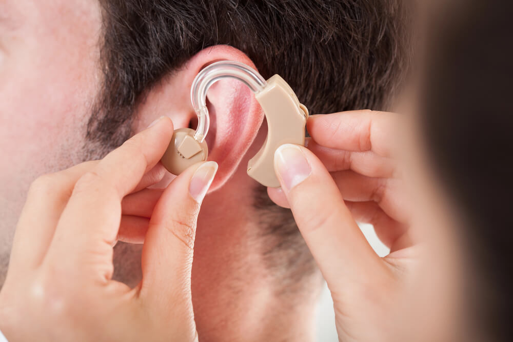 Man is fitted for a free hearing aid.