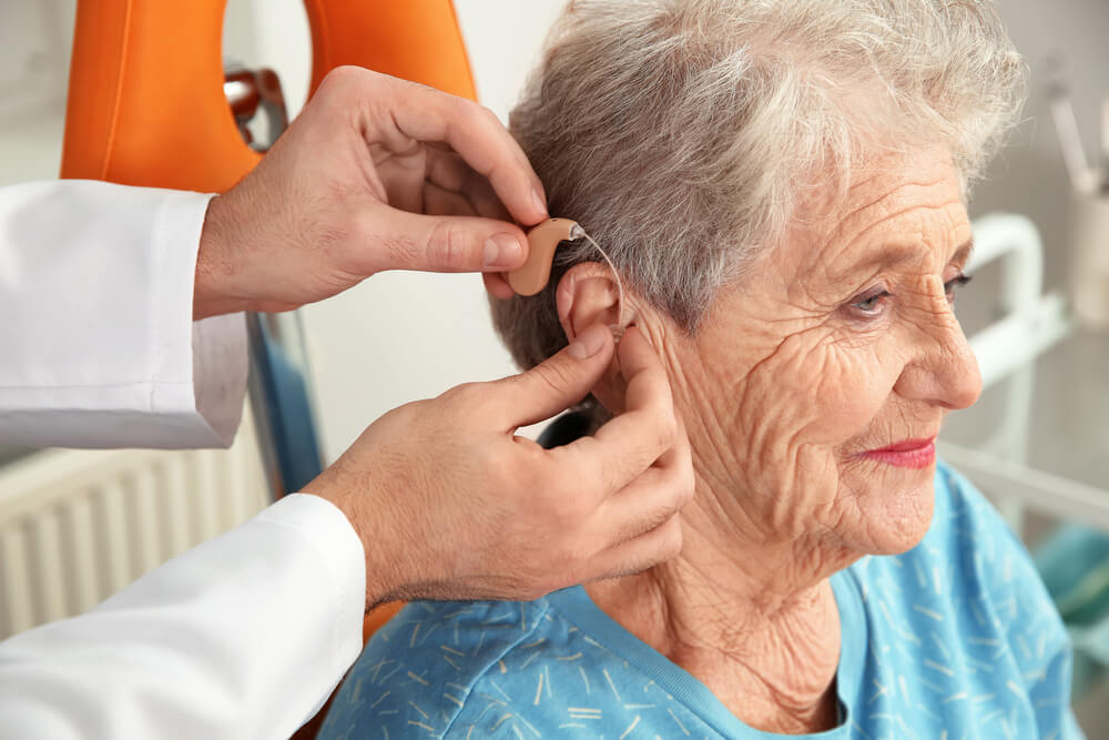 Senior woman gets fitted for free hearing aids.