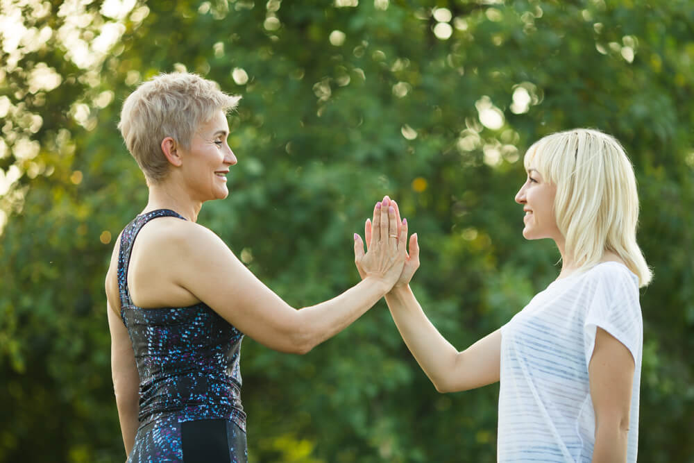 Two women are giving a high-five for motivation. Read here for some tips on how to comfort someone.
