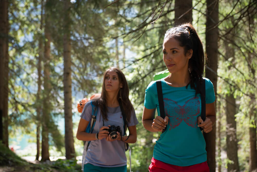 The two women are hiking together. This is a way to team up with other adults.