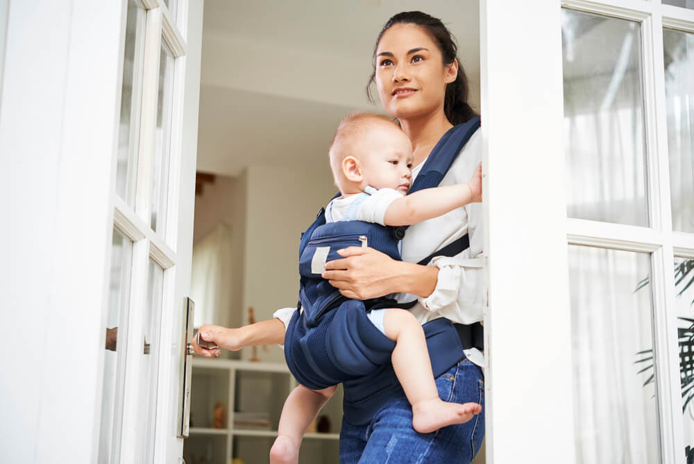 The single mom holding a baby opens front door of her new house. The HomeReady® Mortgage from Fannie Mae is one of the ways you can buy a new home at affordable rates.